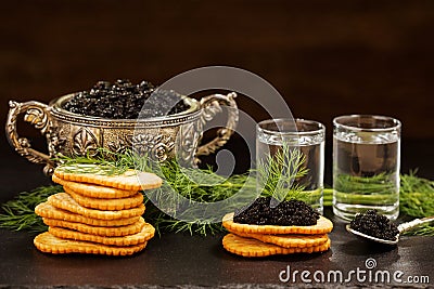Black caviar served on crackers with vodka and additives Stock Photo