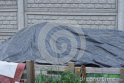 black cellophane covers a pile of sand on the street Stock Photo