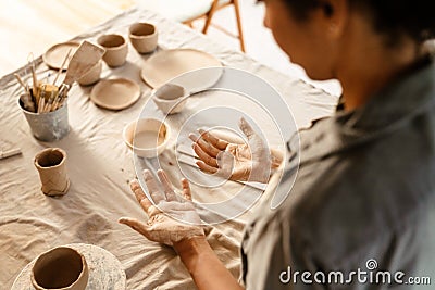 Black ceramist woman looking at her hands while working at her workshop Stock Photo