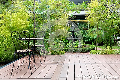 Black chair in wood patio at green garden with fountain in house Stock Photo