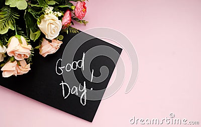 Black chalk board with the inscription good day, pink flower, pink background. Holiday. Copy space. Flat lay. Top view Stock Photo