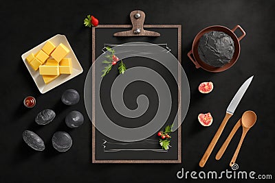 Black chalkboard with a holder with different kitchen items around on a dark gray background, Generative AI Stock Photo