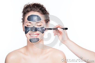 Black charcoal mask application on beautiful woman. Stock Photo