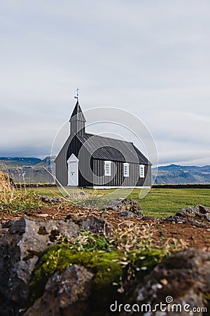 Black church in the meadow and field in Iceland. Icelandic scenic travel destination of religion. Stock Photo