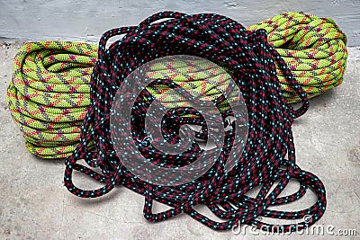 Black climbing ropes are arranged on top of other ropes in a circle Stock Photo