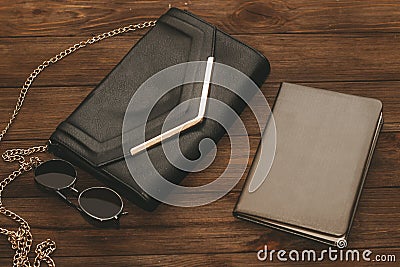 Black clutch bag with a chain and a notebook in a leather cover. Stock Photo