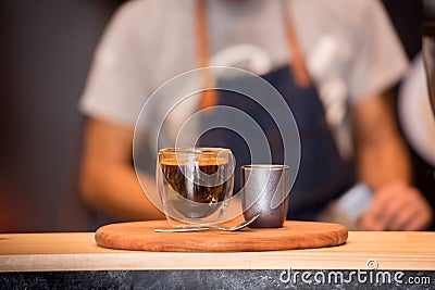 Black Coffee Cup On Wooden Table And Coffee Barista Horizontal and Blurred Background with Film effect. Handsome barista preparing Stock Photo