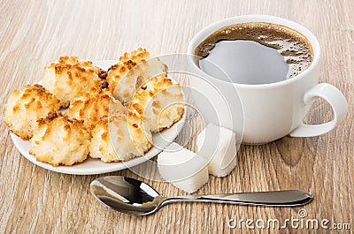Black coffee, lumpy sugar, spoon and saucer with coconut cookies Stock Photo