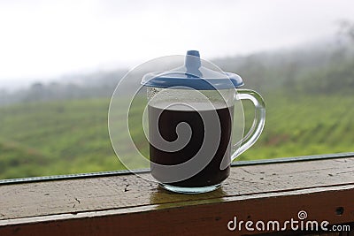 The black coffee in the tea garden is shrouded in mist. a cup of black coffee in a mountainous area. enjoy coffee in the mountains Stock Photo