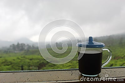 The black coffee in the tea garden is shrouded in mist. a cup of black coffee in a mountainous area. enjoy coffee in the mountains Stock Photo