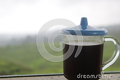 The black coffee in the tea garden is shrouded in mist. a cup of black coffee in a mountainous area. enjoy coffee in the mountains Stock Photo