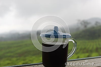 The black coffee in the tea garden is shrouded in mist. a cup of black coffee in a mountainous area. enjoy coffee in the mountains Stock Photo
