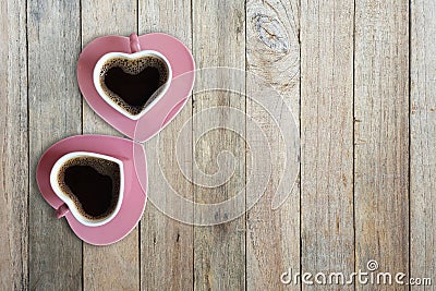 Black coffee in two pink cups heart shape on old wooden floor, Top view, copy space Stock Photo