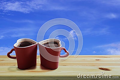 Black coffee in two pink cups heart shape on wooden floor and blue sky background, Copy space or empty space for text Stock Photo