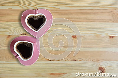 Black coffee in two pink cups heart shape on wooden floor, Copy space or empty space for text Stock Photo