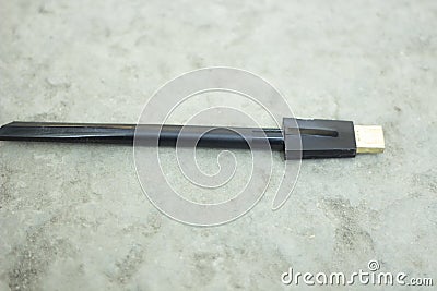A black color cable and the background behind it is a gray Blur Stock Photo