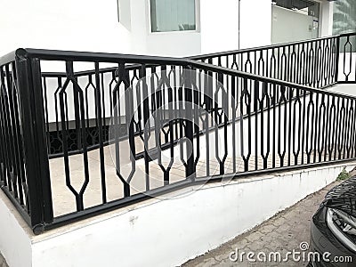 Black color enamel oil painted over the surface of galvanized iron or mild steel handrail or balustrade for an entrance for an Stock Photo