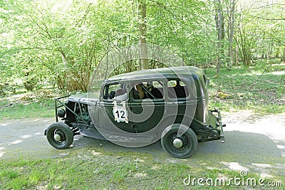Black color Ford V8 Stock car racer classic car from 1934 driving on a country road Editorial Stock Photo