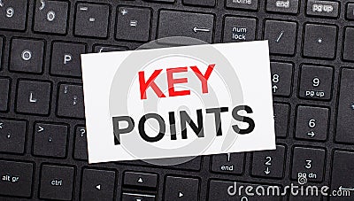 On a black computer keyboard there is a white card with the text KEY POINTS. View from above Stock Photo