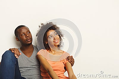 Black couple looking up sitting on floor Stock Photo