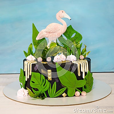 A black creamchease cake with flamingo and tropical leaves Stock Photo