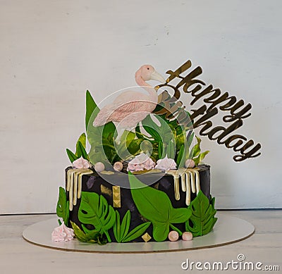 A black creamchease cake with flamingo and tropical leaves Stock Photo