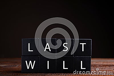 Black cubes with words Last Will on wooden table against dark background Stock Photo