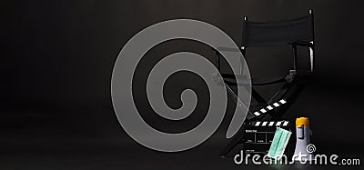 Black director chair , face mask, megaphone and Clapper board or movie slate on black background Stock Photo