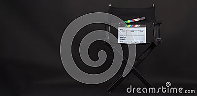 Black Director chair and rainbow clapper board on the chair with a black background Stock Photo