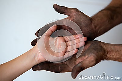 Black dirty man hands holding kid clean hand Stock Photo