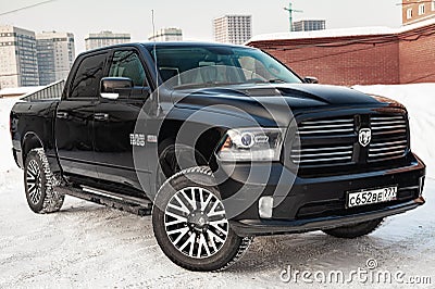 Black Dodge Ram with an engine of 5.7 liters front view on the car parking with snow background Editorial Stock Photo