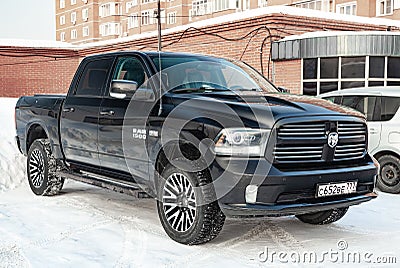 Black Dodge Ram with an engine of 5.7 liters front view on the car parking with snow background Editorial Stock Photo