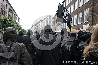 Black dressed protesters on a demonstration march through the streets of Lubeck against German politics and for accommodation of Editorial Stock Photo