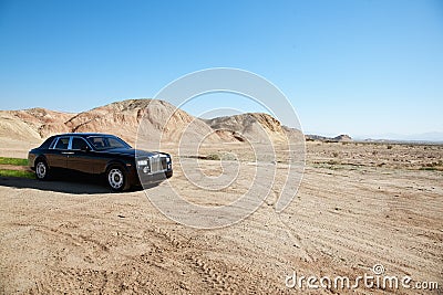 Black eco-friendly Rolls Royce car running off-road on unpaved road Stock Photo