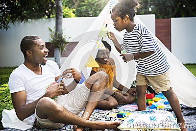 Black family enjoying summer together at backyard blowing soap b Stock Photo