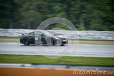 Black fast sports japanese car drives along a racing circuit. Editorial Stock Photo