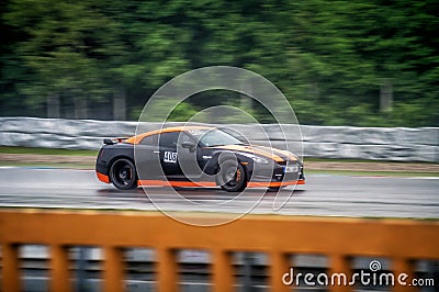 Black fast sports japanese car drives along a racing circuit. Editorial Stock Photo