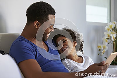 Black father and daughter relaxing in bed look at each other Stock Photo