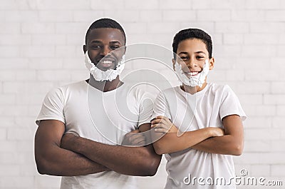 Black father and sun posing with foam beard and folded arms Stock Photo