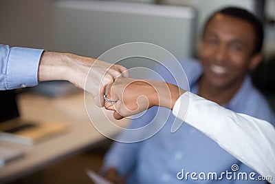 Black female caucasian man fist bumping closeup focus on hands Stock Photo