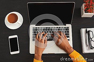 Black female hands typing on laptop keyboard, top view Stock Photo