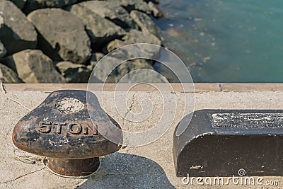 Black five ton dock cleat on concrete pier Stock Photo