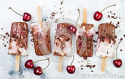 Black Forest chocolate fudge popsicles with roasted cherries and coconut cream. Vegan creamy ice pops, nicecream, fudgesicles. Stock Photo