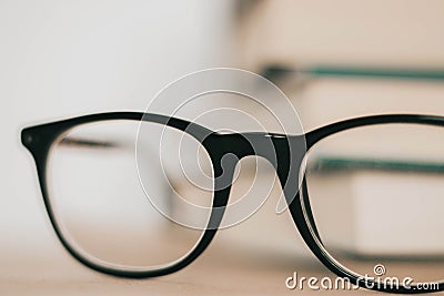 Black frame glasses in front of pile of books Stock Photo