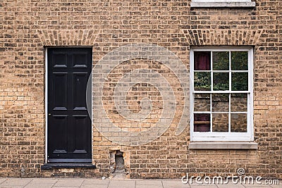 Black front door on a restored brick wall of a Victorian house r Stock Photo