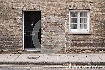 Black front door on a restored brick wall of a Victorian house residential building Stock Photo