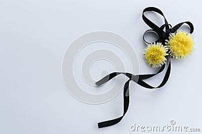 Black funeral ribbon with two yellow flowers. Stock Photo