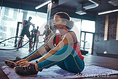 Black girl doing crunching exercise in gym Stock Photo