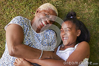 Black girl and grandmother lying on grass, overhead close up Stock Photo