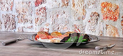 Black glass plate with lunch, beef on with potatoes and grilled vegetables Stock Photo